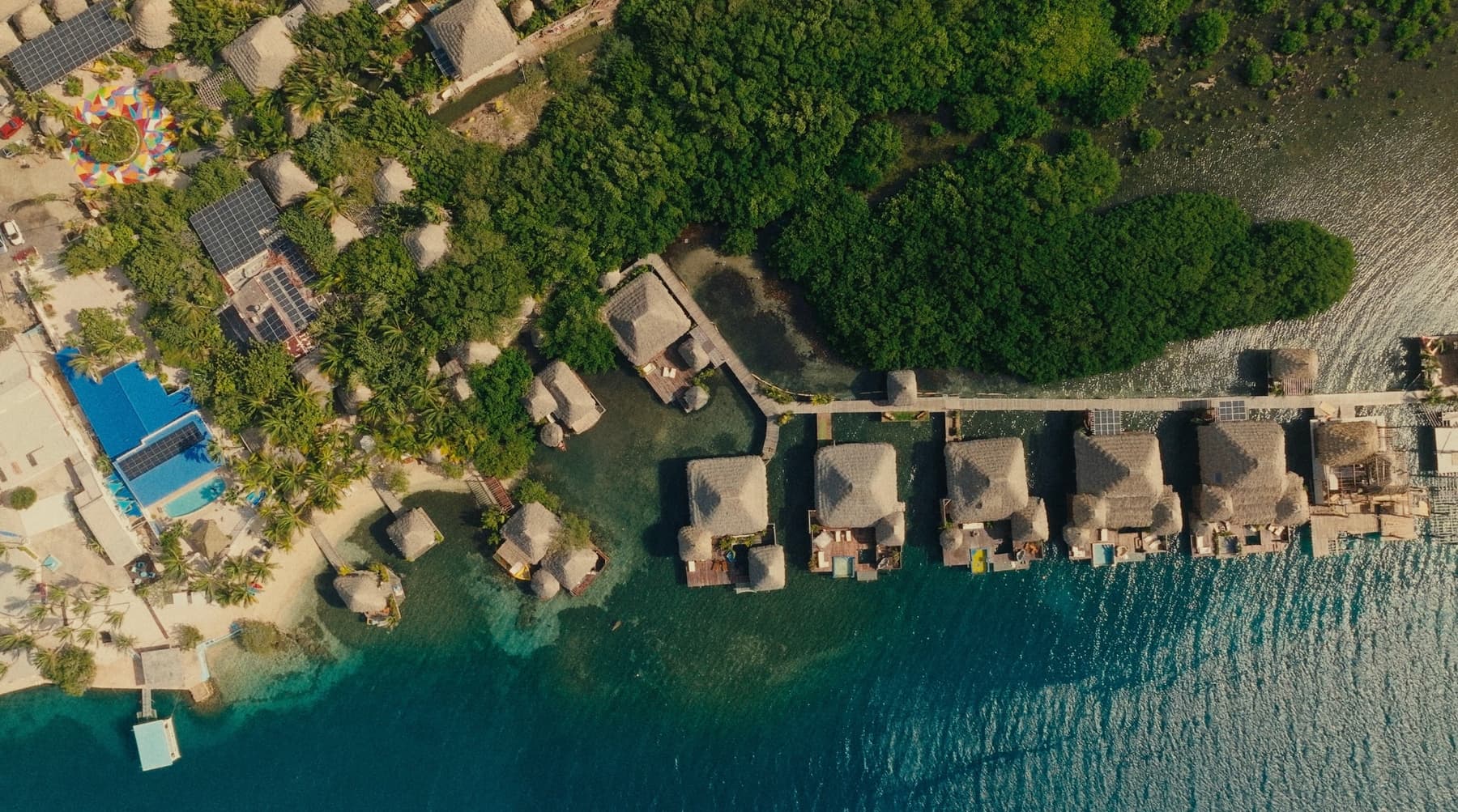 Aerial view of thatched overwater bungalows on turquoise water — Ground, Thursday